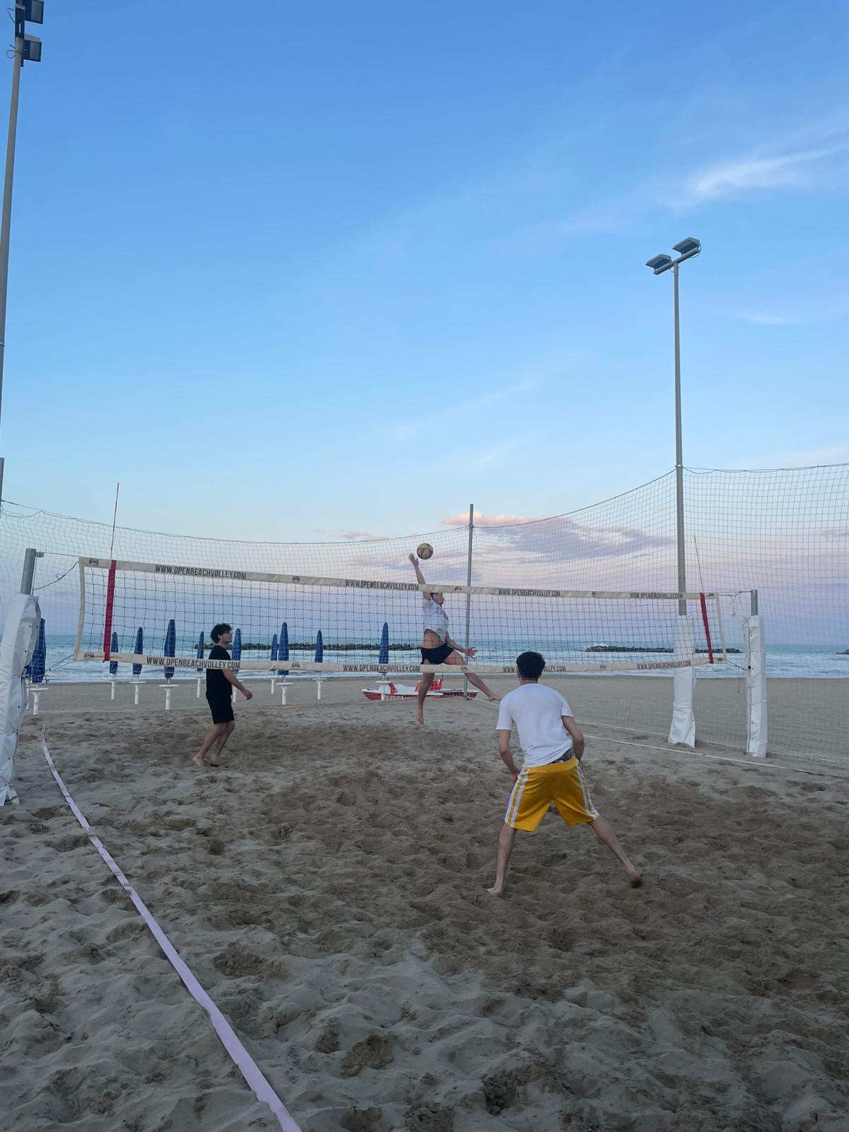 Partita di beach volley al tramonto sulla spiaggia