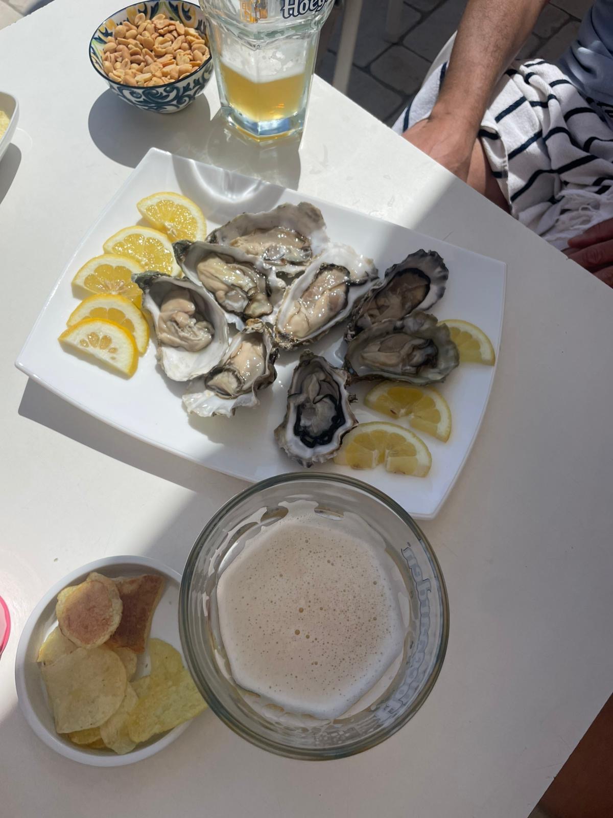 Piatto di ostriche fresche con limone e birra